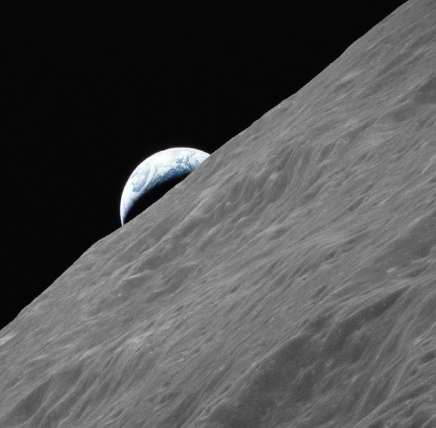A crescent of Earth rises above the lunar horizon photographed from Apollo 17 in lunar orbit.