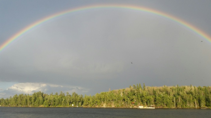 Rainbow over lake and treeline