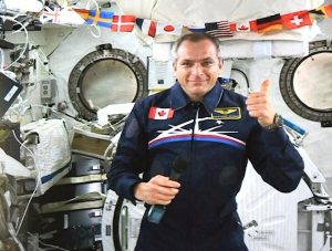 Image of astronaut David Saint-Jacques in space with thumbs-up