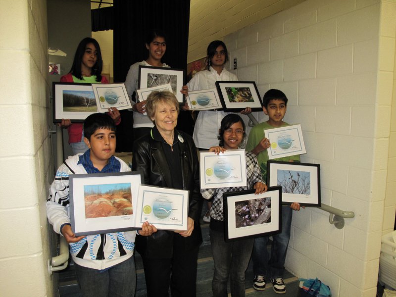 Dr Roberta Bondar with student winners holding their certificates and framed winning submissions