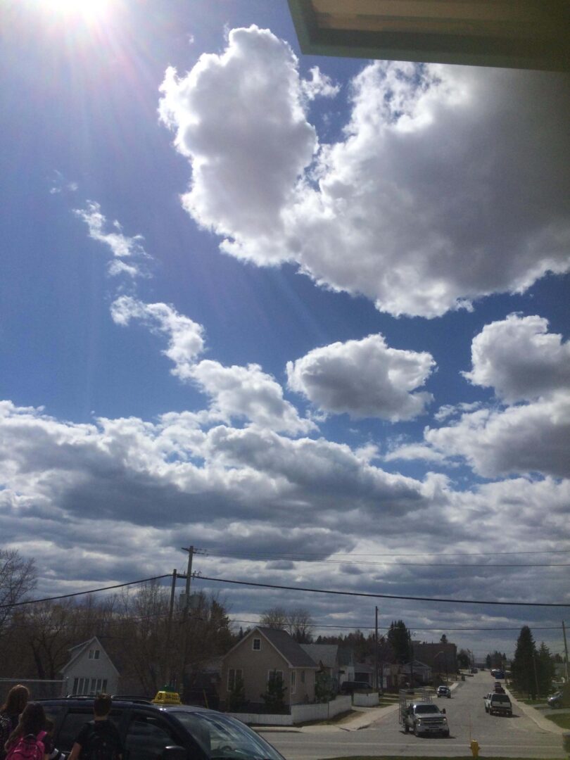 Image of blue sky with clouds over a town