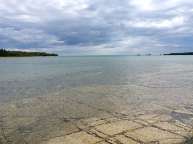 Image of lake with clear water showing rocky bottom