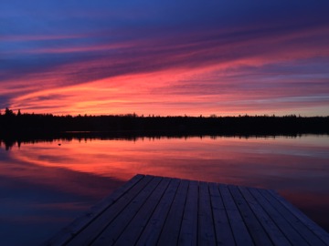 Image of blue and red sky at sunset reflected on lake