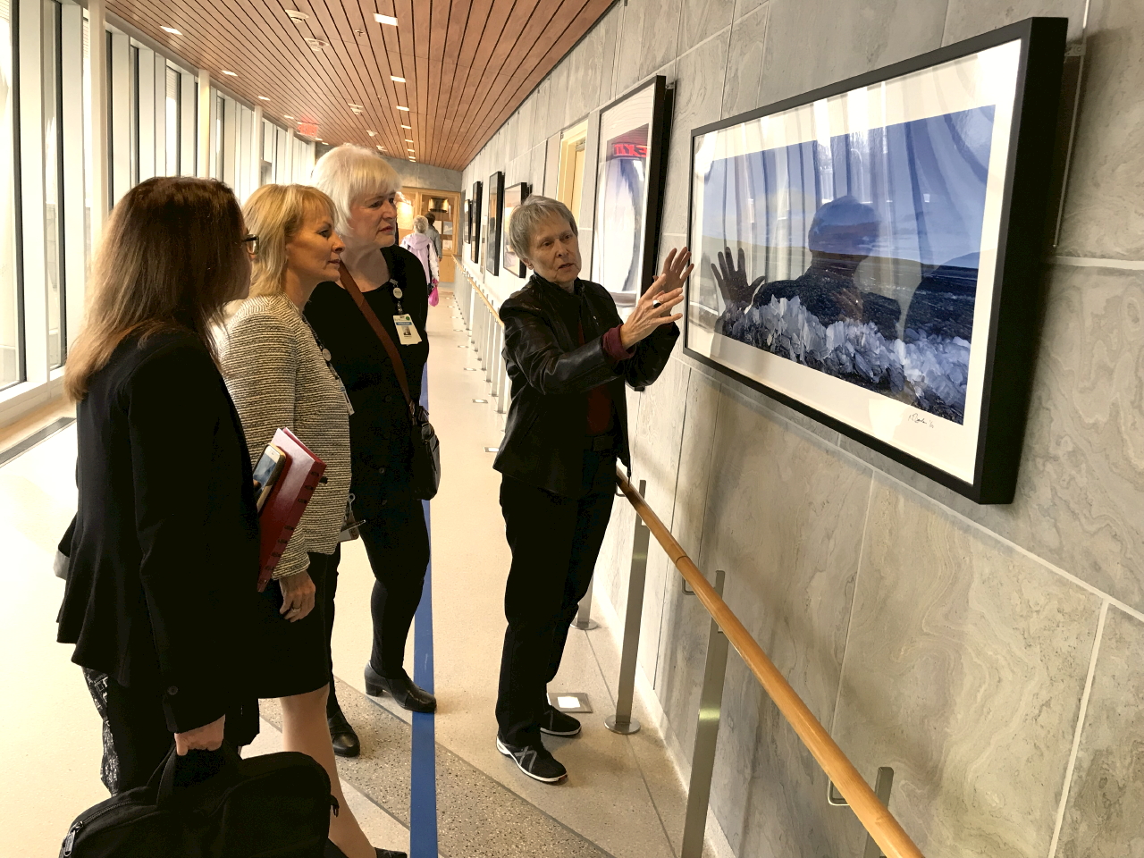 Image of people looking at an image in a gallery