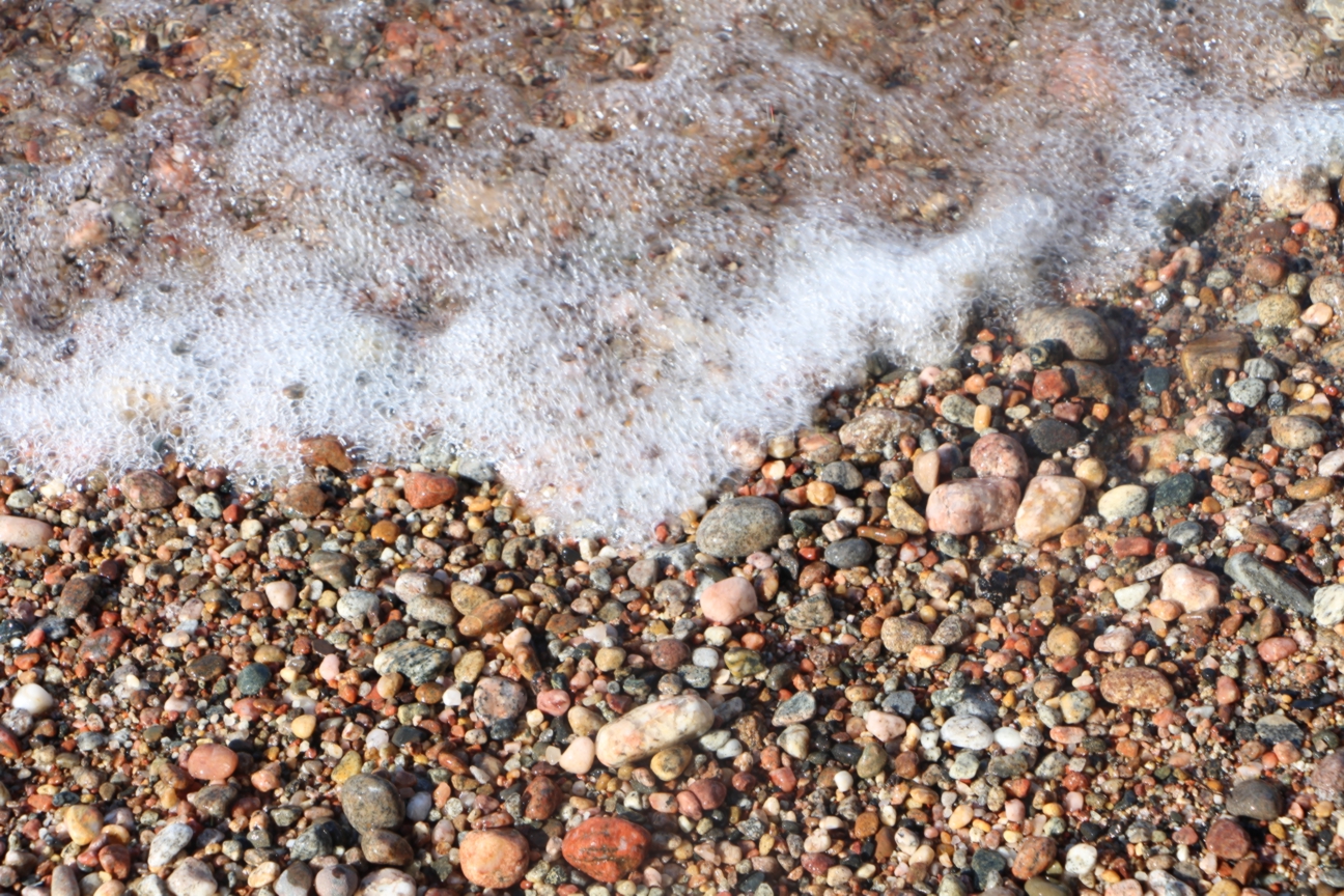 Image of a rocky beach meeting foamy waves