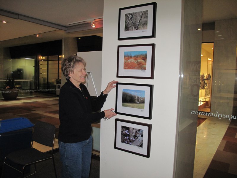 Dr. Bondar hanging student winning submissions in the Travelling Exhibition and Learning Experience at the First Canadian Place Gallery for public display