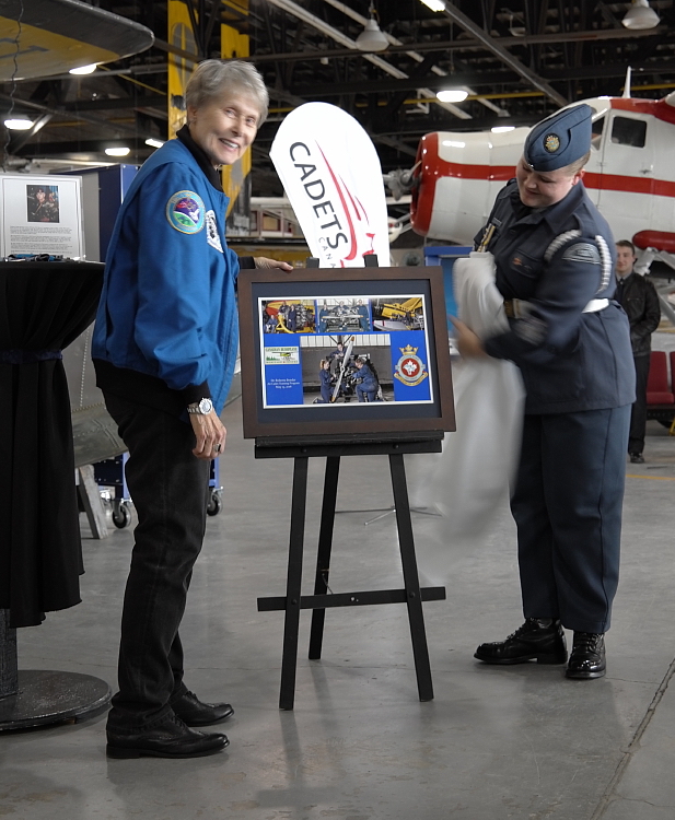 Dr Bondar grins as 155 Air Cadet Sqn. Cadet WO1 Christiane Boudreau unveils the plaque