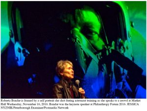 Image of Roberta Bondar speaking in front of photo of herself