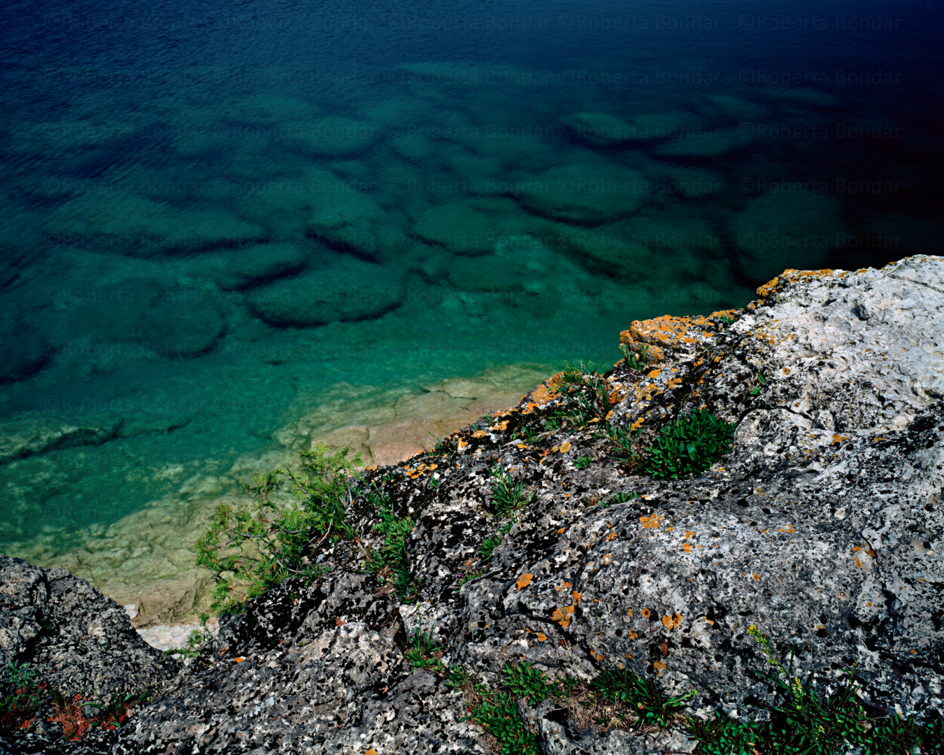 Rocky shoreline with clear blue and green water