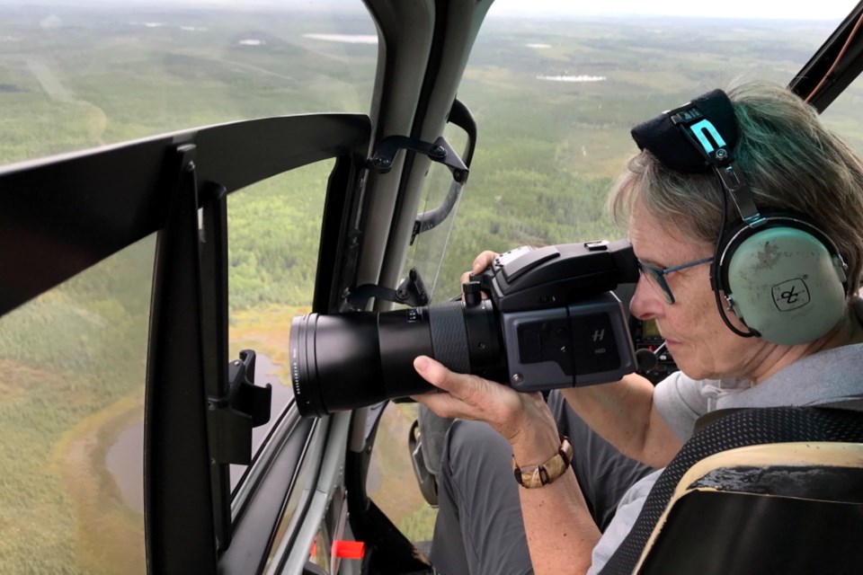 Dr Roberta Bondar takes photographs from inside a helicopter